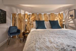 1 dormitorio con 1 cama con cabecero de madera y silla en Woodlands Family Retreat Windermere with Hot Tub and Sauna, en Windermere