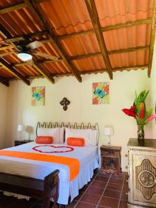 1 dormitorio con 1 cama con edredón naranja y blanco en Thermal Paradise Villa en Caluco