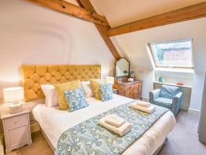 ein Schlafzimmer mit einem großen Bett und einem Stuhl in der Unterkunft Lady Pond Retreat in Ashbourne