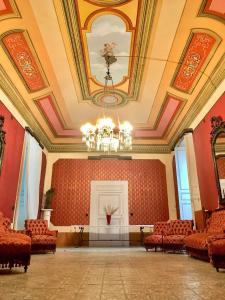 une grande chambre avec des chaises et un lustre dans l'établissement Palazzo Introna, à Mola di Bari