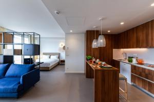 a living room and kitchen with a blue couch at Oscar Concept Apartments in Lisbon