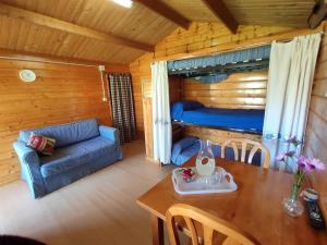 - un salon avec une table, un canapé et un lit dans l'établissement CAMPING A GRANDELLA, à El Franco