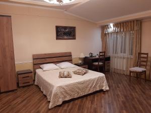 a bedroom with a bed and a table and chairs at Hotel Mirazh in Yessentukskaya