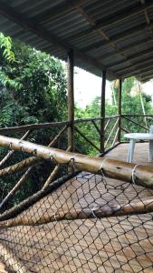 a net on a wooden deck with a table at Casa Mar e Montanha 2, deck com vista para o mar in Trindade