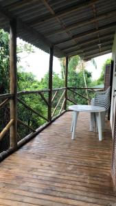 - une terrasse couverte en bois avec un banc dans l'établissement Casa Mar e Montanha 2, deck com vista para o mar, à Trindade
