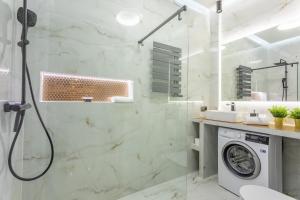 łazienka z prysznicem i pralką w obiekcie Ambria Apartments Platan Tower w Świnoujściu +37 zdjęć