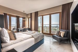 sypialnia z łóżkiem, krzesłem i oknami w obiekcie Ambria Apartments Platan Tower w Świnoujściu