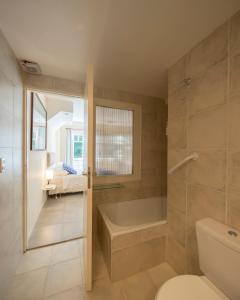 Un baño con bañera, inodoro y lavabo. en Hotel Arcoiris, en Villa Gesell
