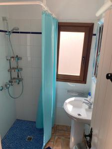 uma casa de banho com uma cortina de chuveiro azul e um lavatório. em Can Xica em Sant Josep de sa Talaia