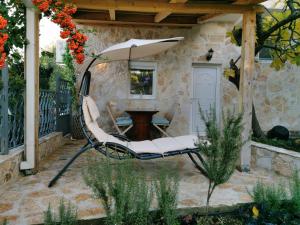 een patio met een stoel en een parasol bij STUDIO Carpe Diem in Utjeha