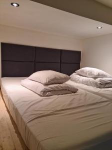 ein großes Bett mit weißer Bettwäsche und Kissen in der Unterkunft AMBER APARTAMENt #12 in Krakau