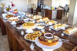 a table topped with lots of different types of pastries at Hotel Porto Sol Ingleses in Florianópolis