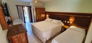 a small bedroom with two beds and a window at Pousada Casa de Praia in Praia do Forte +21 photos