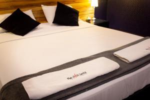 a bed with two white towels on it at The Clock Hostel & Suites in Cartagena de Indias
