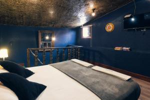 a bedroom with a bed with a blue wall at The Clock Hostel & Suites in Cartagena de Indias