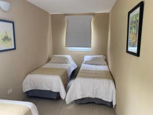 a room with two beds and a window at Silenios in Pinamar