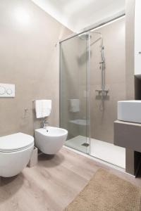 uma casa de banho com um WC e uma cabina de duche em vidro. em Redi Suite em Bari