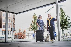 a man and a woman with a dog and a suitcase at Hotel Atlantic in Aarhus