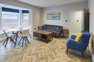 uma sala de estar com um sofá, uma mesa e cadeiras em Host & Stay - Bellevue Apartments em Redcar