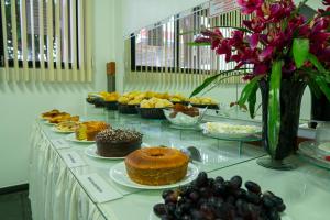 a buffet filled with different types of cakes and desserts at Pousada Paraiso in Guanambi