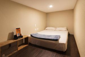 a small room with a bed and a box on it at The Clock Hostel & Suites in Cartagena de Indias