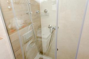 een douche met een glazen deur met een slang bij Apartman Amsterdam Jahorina in Jahorina +26 foto's