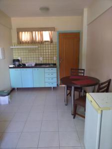 uma cozinha com uma mesa e uma mesa e uma sala de jantar em Condomínio Flat La Perla em Fortaleza