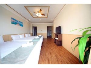 ein Hotelzimmer mit 2 Betten und einem Flachbild-TV in der Unterkunft Green Garden Hills 3F-1 - Vacation STAY 15233v in Okinawa