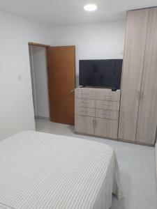 譚岡加的住宿－Emvacamo'，一间卧室配有一张床和一台平面电视