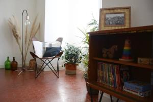 - un salon avec une chaise et une étagère dans l'établissement 85 m2 centre ville 2 mn vieux Port au calme, à Marseille