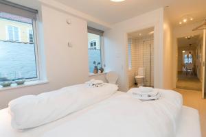 2 camas blancas en una habitación con ventana en Harbour Walk, en Sønderborg