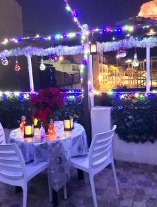 - une table avec des chaises et des lumières sur la terrasse dans l'établissement Alojamiento Centro San Anton, à Alicante