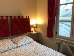 een slaapkamer met een bed, een raam en een lamp bij Les logettes in Honfleur