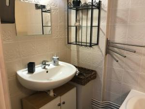 een badkamer met een witte wastafel en een spiegel bij Les logettes in Honfleur +27 foto's