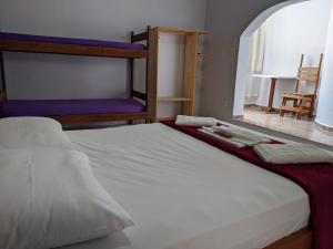 a bedroom with two bunk beds with white sheets at Pousada Vila Appia in Cabo Frio