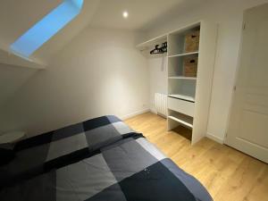 una camera con un letto bianco e nero e un armadio di La Sècherie de Waldam pour 4 personnes a Oye-Plage