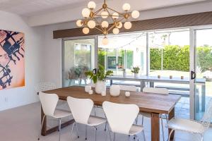 une salle à manger avec une table en bois et des chaises blanches dans l'établissement Enjoy Life Permit# 3333, à Palm Springs