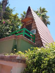una casa con un balcón verde en la parte superior en Cabañas Rústicas El Benny by Rotamundos, en Loreto