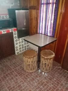 - une table et deux tabourets dans la cuisine dans l'établissement Cabañas Rústicas El Benny by Rotamundos, à Loreto