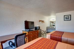 a hotel room with two beds and a flat screen tv at Motel 6 Branson, Mo in Branson