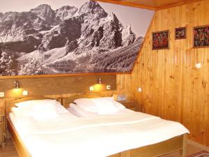a bedroom with a bed with a mountain mural on the wall at Kalina 2 in Zakopane