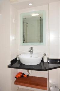 ein Bad mit einem Waschbecken und einem Spiegel in der Unterkunft Apartamento Chiado Carmo 53 in Lissabon