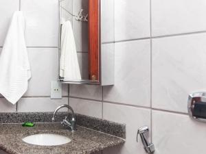 a bathroom with a sink and a mirror at Pousada Recanto do Mucugê in Arraial d'Ajuda