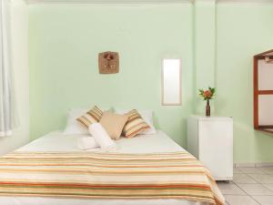 a bedroom with a bed with a striped blanket at Pousada Recanto do Mucugê in Arraial d'Ajuda