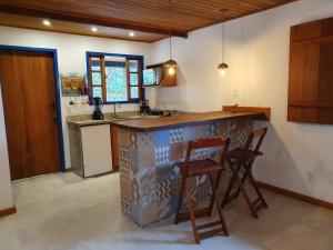 盧米亞爾的住宿－A Casinha Lumiar，厨房配有柜台和2把凳子