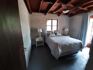 a bedroom with a bed and a ceiling fan at Rock Cottage, Bela-Bela in Bela-Bela