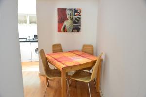 einen Esstisch mit Stühlen und ein Gemälde an der Wand in der Unterkunft Apartamento Chiado Carmo 53 in Lissabon