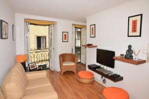 ein Wohnzimmer mit einem Sofa und einem TV in der Unterkunft Apartamento Chiado Carmo 53 in Lissabon