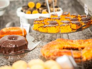 a display of different types of pastries and desserts at Pousada Recanto do Mucugê in Arraial d'Ajuda