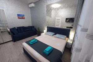 een slaapkamer met een groot bed en een blauwe bank bij New cozy apartment near Opera House and “Malevich” in Lviv